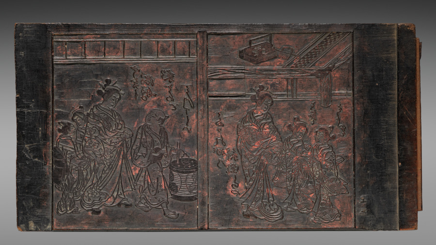 An Edo-period carved wooden printing block, figures cut in relief with dark ink still held in the grain