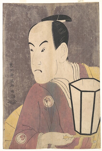 A kabuki actor holding a lantern, wearing a maroon robe over a yellow under-robe, against a pale mica ground.